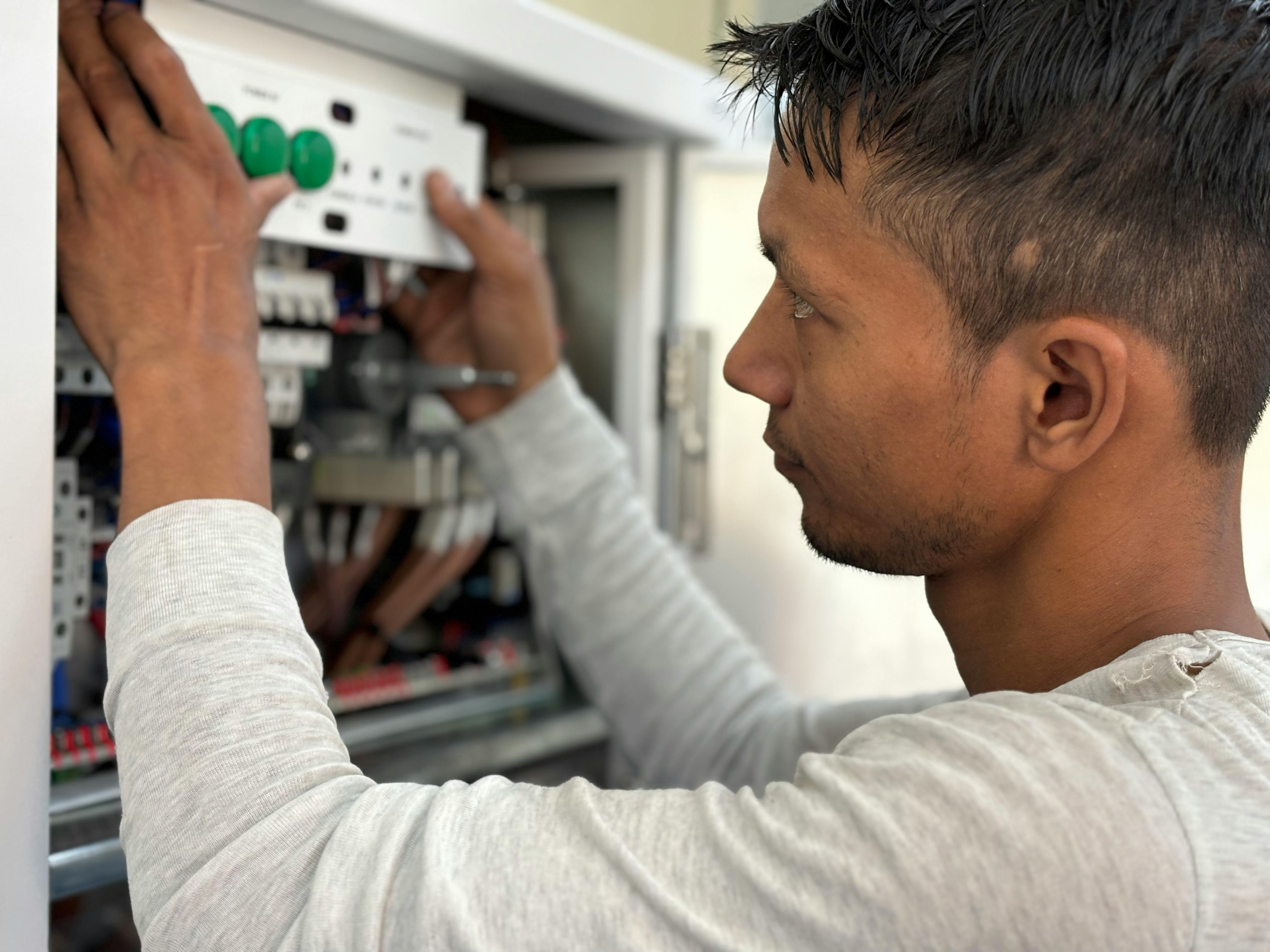 Electrician reviewing an electrical panel inside a home